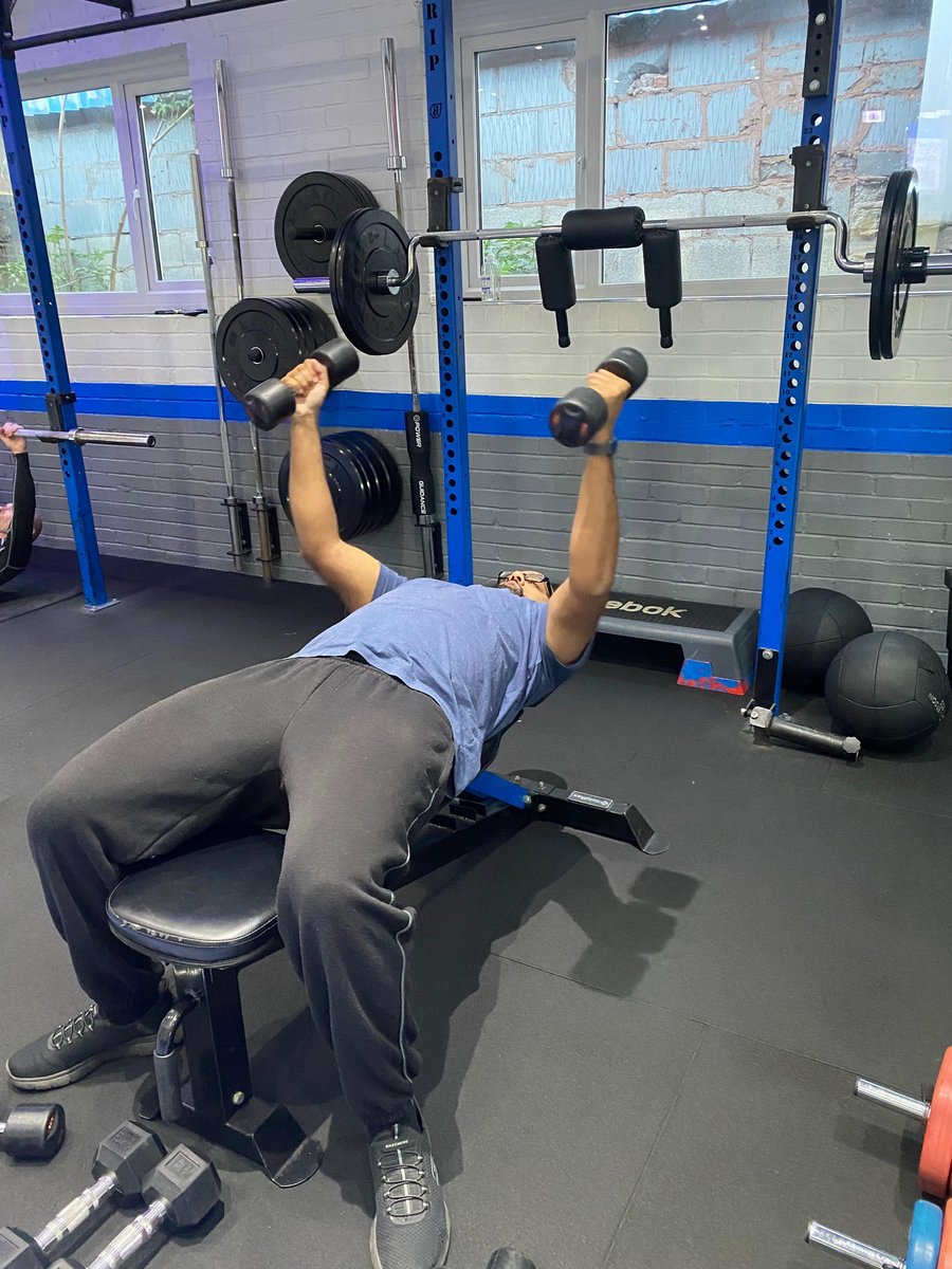 SPS Fitness member doing dumbbell bench press in the squat rack area